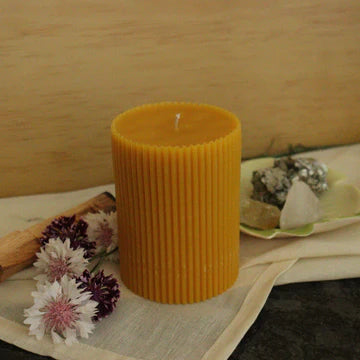 100% beeswax candle on a cloth with flowers