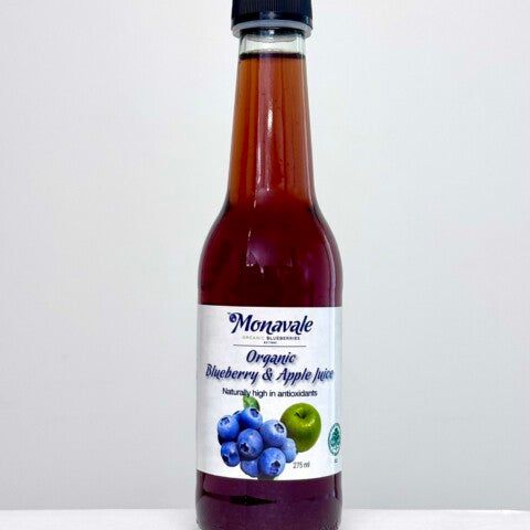 A bottle of Monavale Organic Blueberry & Apple Juice with a white label and black cap, set against a plain light gray background.
