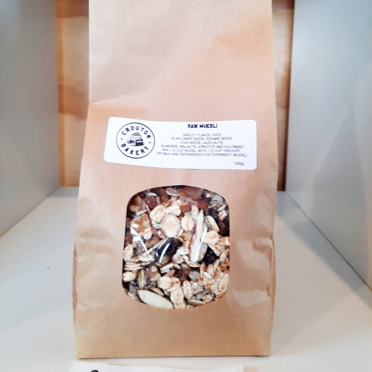 A 500g paper bag of Chouder Bakery Raw Oats, showing the kraft paper packaging with a clear window displaying the mixed oats inside.