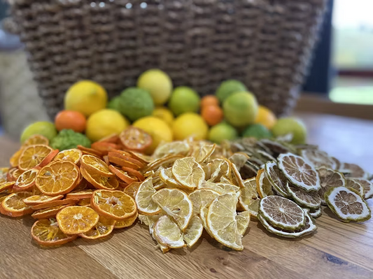 Piles of dried spray free lemon, lime and orange slices on a wooden table