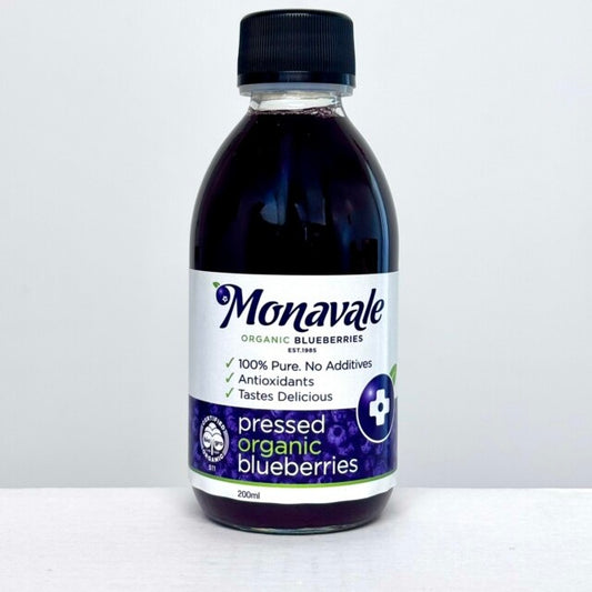 Monavale certified organic bluberry pressed juice in a glass bottle with a black lid in a white background.
